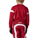 Red SHIFT racing suit with white accents on a gray background for motocross kids