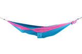 Ticket to the Moon Original Outdoor Hammock set up between trees in a park. AQUA PINK