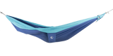 Ticket to the Moon Original Outdoor Hammock set up between trees in a park. Blue